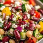 Zesty Mediterranean Bean Salad with Feta 6 A large white bowl of Mediterranean Bean Salad with Feta, chickpeas, cherry tomatoes, cucumbers, Kalamata olives, and fresh parsley