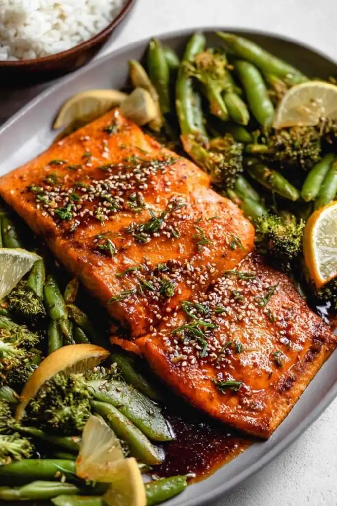 Baked miso salmon fillet with caramelized miso glaze on a sheet pan with roasted broccoli, edamame, and carrots