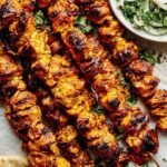 Chicken Shawarma Kebab 24 Chicken shawarma kebab skewers grilling on a cast iron pan with golden char marks and aromatic spice coating