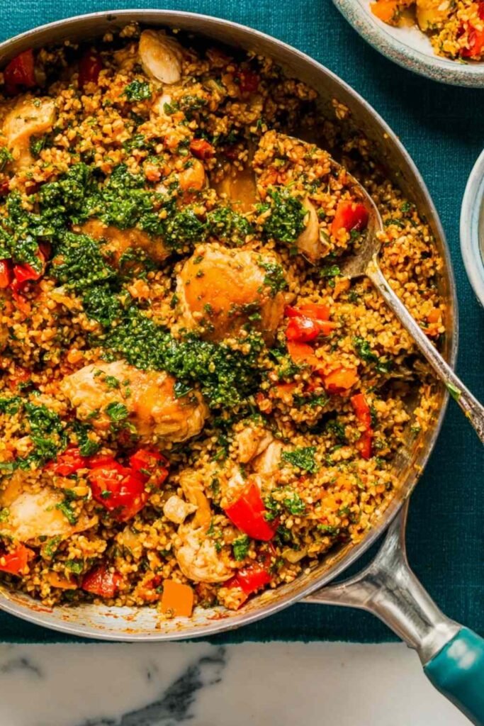Chicken with Bulgur 5 Chicken with bulgur recipe served in a cast iron skillet topped with feta and fresh parsley