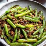 Chinese Green Beans and Ground Beef 12 Chinese green beans and ground beef stir-fry with blistered green beans and caramelized beef in a wok