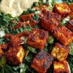 Crispy Buffalo Tofu Caesar Salad in a large bowl with romaine, buffalo tofu, vegan parmesan, and croutons