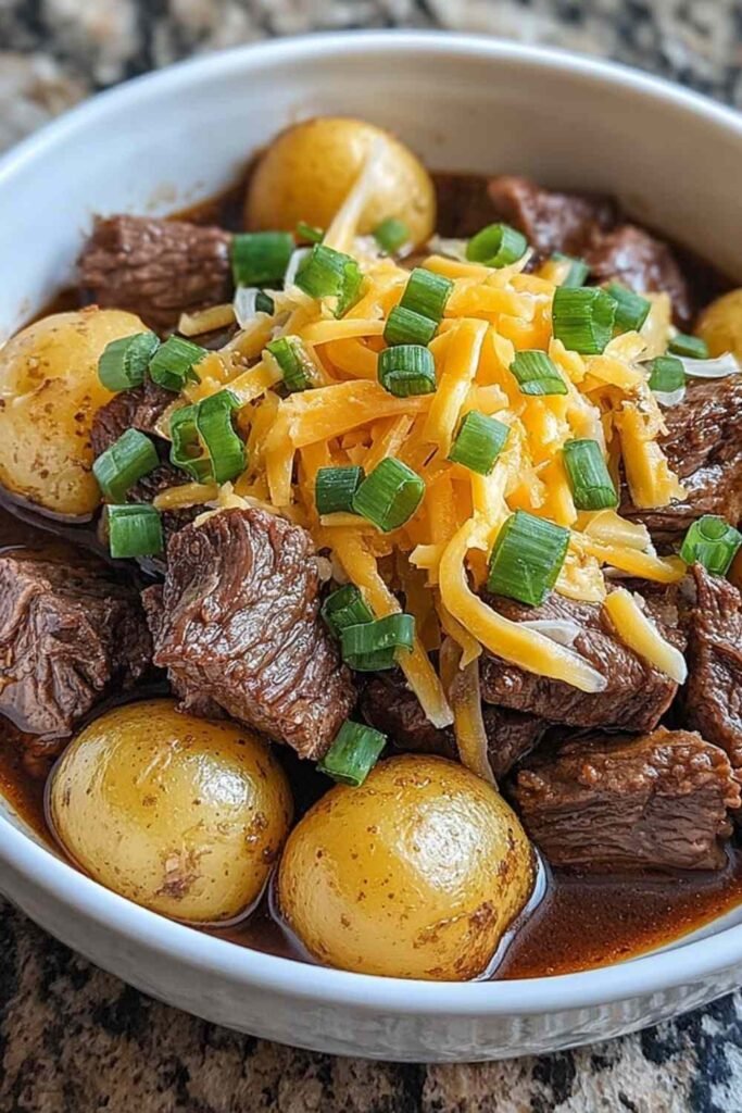 Crockpot Loaded Steak and Potato Bake 29 Crockpot Loaded Steak and Potato Bake with melted sharp cheddar and fresh chives served hot from the slow cooker