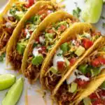 Overhead view of easy vegan tacos shredded tofu taco meat in corn taco shells topped with guacamole, pico de gallo, and fresh cilantro