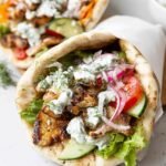 Epic vegan gyros with tzatziki stuffed with crispy shaved tofu, mushrooms, fresh romaine, tomatoes, and dairy-free tzatziki in a warm pita