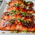 Gochujang Salmon 9 Broiled gochujang salmon fillets garnished with sesame seeds and green onion on a white plate
