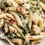 High Protein Pasta 30 Creamy high protein pasta with Cajun chicken, sun-dried tomatoes, and spinach in a white bowl