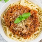 High Protein Tempeh Bolognese 18 Bowl of high protein tempeh bolognese over chickpea pasta topped with fresh basil and cashew parmesan