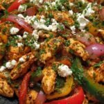 Mediterranean Chicken Stir Fry with golden chicken, zucchini, kalamata olives, and feta in a cast iron skillet