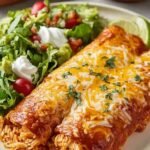 Quick Rotisserie Chicken Enchiladas 3 Rotisserie chicken enchiladas in a 9x13 baking dish topped with melted cheddar, sour cream, and fresh cilantro