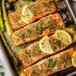 Overhead view of sheet pan salmon fillets with roasted Brussels sprouts on a rimmed baking sheet