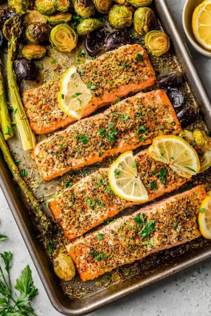 Overhead view of sheet pan salmon fillets with roasted Brussels sprouts on a rimmed baking sheet