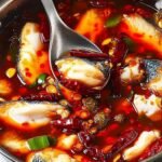 Sichuan Spicy Fish 21 Bowl of Sichuan Spicy Fish with red chili oil drizzle, spring onions, and blanched snow peas in spicy doubanjiang broth