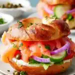Smoked Salmon Bagel 15 Classic smoked salmon bagel recipe with cream cheese, capers, fresh dill, and vegetables on a wooden board