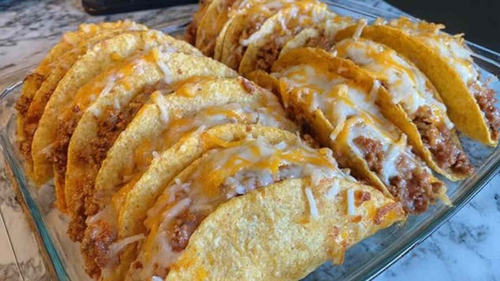 Spicy Baked Tacos 7 Spicy baked tacos in a 9x13 baking dish with melted cheese and crispy corn shells straight from a 400 degree oven
