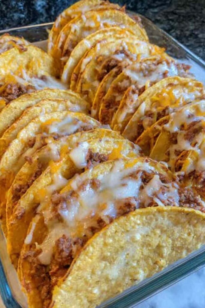 Spicy Baked Tacos 8 Spicy baked tacos in a 9x13 baking dish with melted cheese and crispy corn shells straight from a 400 degree oven