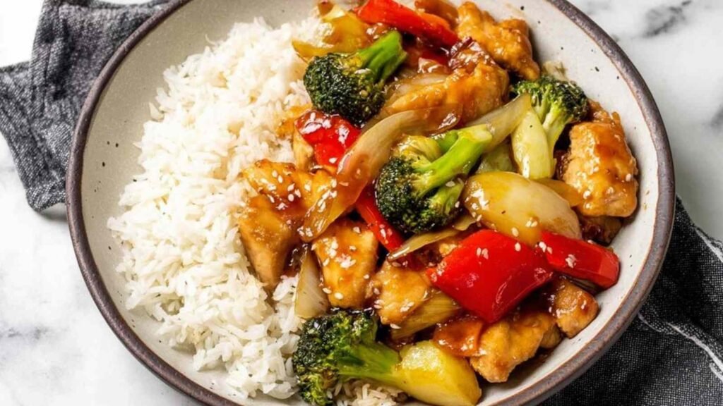 Teriyaki chicken stir fry with broccoli and red bell pepper in a deep skillet coated in homemade sticky teriyaki sauce