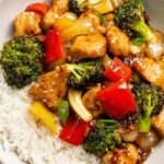 Teriyaki chicken stir fry with broccoli and red bell pepper in a deep skillet coated in homemade sticky teriyaki sauce