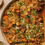 Tofu Fried Rice High Protein 9 High protein tofu fried rice with crispy golden tofu, peas, and carrots in a large wok