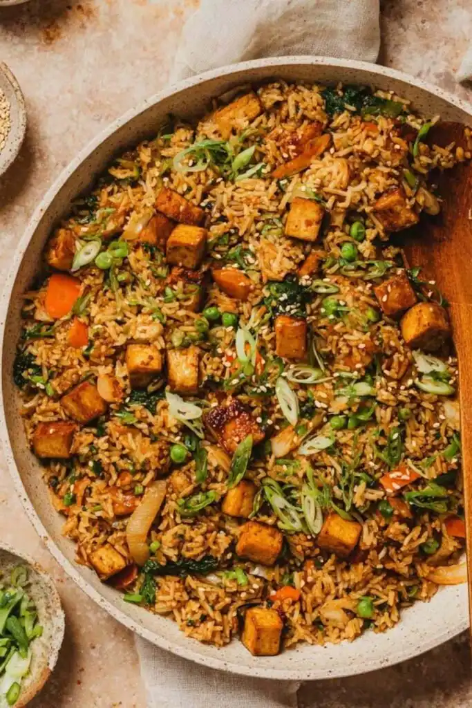 Tofu Fried Rice High Protein 8 High protein tofu fried rice with crispy golden tofu, peas, and carrots in a large wok