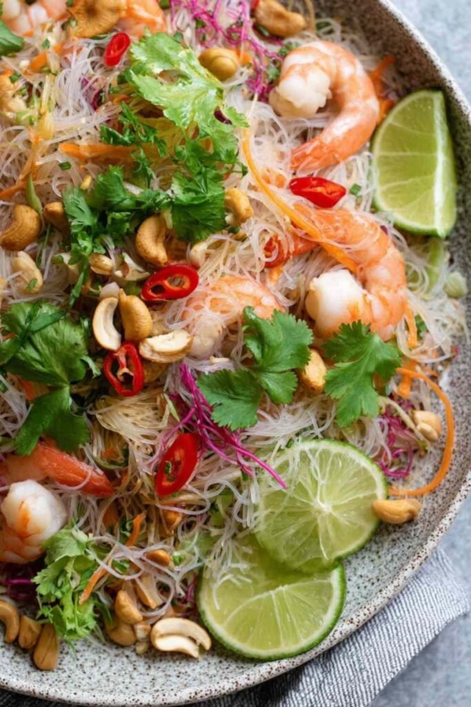 Yum Woon Sen (Thai Glass Noodle Salad) 2 Yum Woon Sen Thai glass noodle salad with wild prawns, pork, cashews, and fresh cilantro served in a large white dish