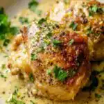Baked Greek Yogurt Chicken in a 9x13 baking dish with golden caramelized edges and fresh parsley garnish
