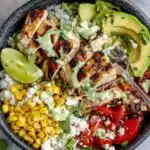 Cilantro Lime Chicken and Rice Bowls with Spicy Green Goddess Dressing 18 Cilantro lime chicken and rice bowl topped with sliced grilled chicken, avocado, cherry tomatoes, grilled corn, cotija cheese, and green goddess dressing