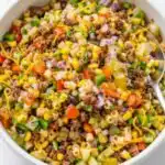 Cowboy Pasta Salad 9 Large bowl of cowboy pasta salad with seasoned ground beef, black beans, cherry tomatoes, cheddar cheese, and fresh cilantro