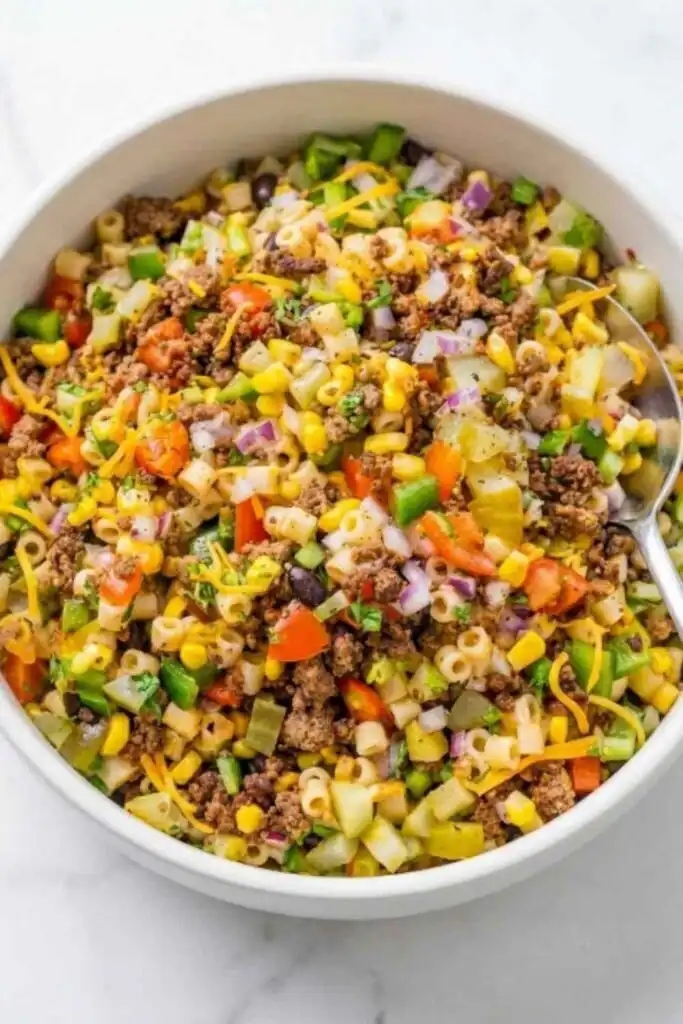 Cowboy Pasta Salad 8 Large bowl of cowboy pasta salad with seasoned ground beef, black beans, cherry tomatoes, cheddar cheese, and fresh cilantro