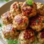 High protein Greek turkey meatballs with tzatziki served in a bowl with fresh dill and lemon wedges
