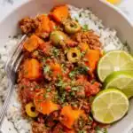Mexican Picadillo 3 Overhead view of Mexican Picadillo in a cast iron skillet with ground beef, sweet potato, green olives, and a squeeze of lime