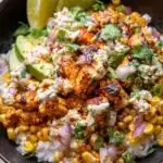 Street Corn Chicken Rice Bowl topped with creamy cotija lime street corn, sliced avocado, and smoky spiced chicken over white rice