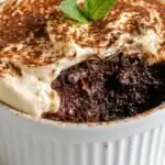 Summer Mocha Protein Power Baked Oats 9 Overhead view of Summer Mocha Protein Power Baked Oats topped with creamy mocha yogurt ganache frosting and dusted with unsweetened cocoa powder in a small white ramekin