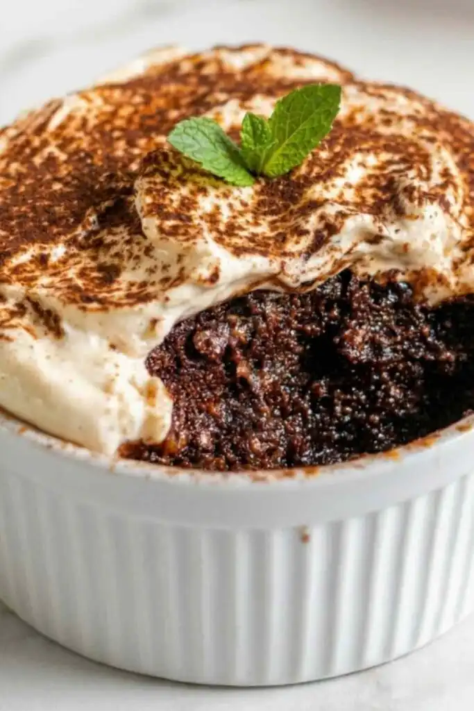 Summer Mocha Protein Power Baked Oats 8 Overhead view of Summer Mocha Protein Power Baked Oats topped with creamy mocha yogurt ganache frosting and dusted with unsweetened cocoa powder in a small white ramekin