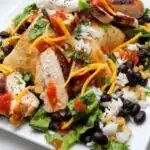 Naked Chicken Burrito Bowl 18 Overhead view of a naked chicken burrito bowl with grilled chicken strips, black beans, corn, rice, sour cream, and chipotle salsa