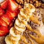 Chocolate Peanut Butter Protein Yogurt Bowl 12 Chocolate peanut butter protein yogurt bowl topped with granola and fresh strawberries in a white bowl