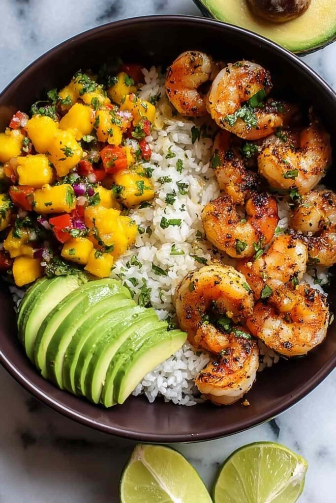 Shrimp and Avocado Bowls with Mango Salsa and Lime-Chili Sauce served over rice, viewed from above with cilantro garnish