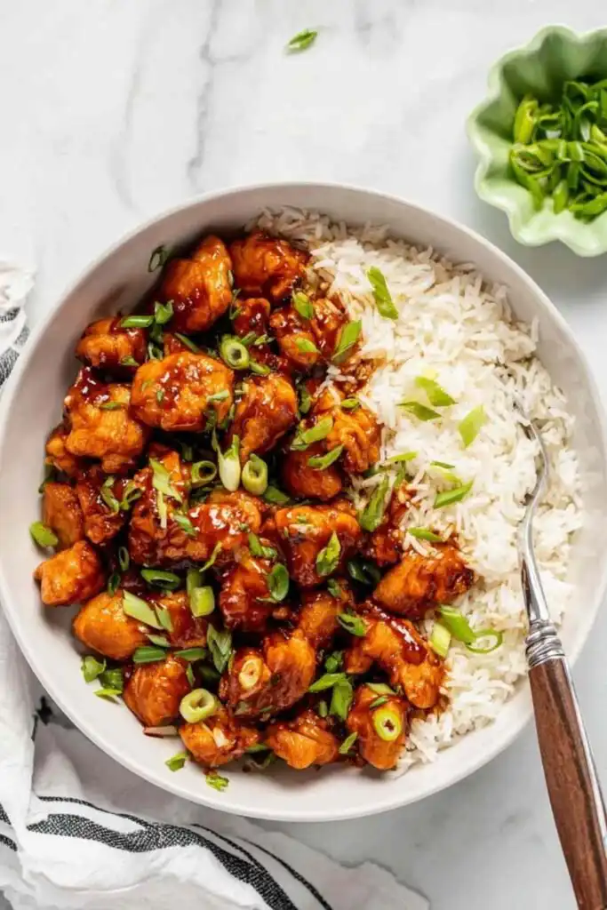 Glazed Chicken 11 Glazed chicken pieces in a skillet coated in a thick sweet and savory sauce garnished with green onions