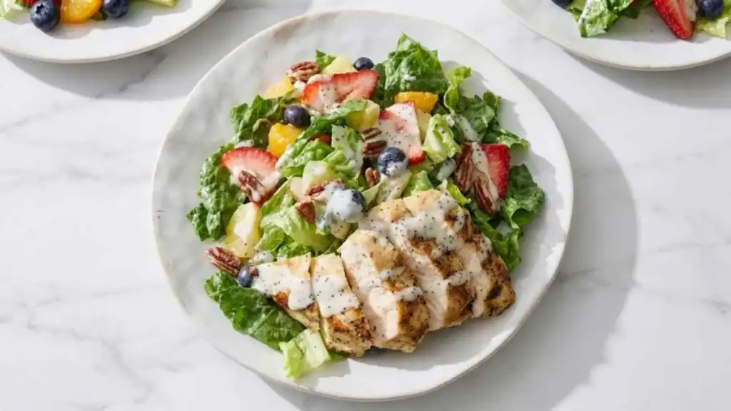 Copycat Panera Strawberry Poppyseed Chicken Salad 13 Copycat Panera Strawberry Poppyseed Chicken Salad on a white plate with sliced grilled chicken, fresh strawberries, blueberries, toasted pecans, and creamy poppy seed dressing