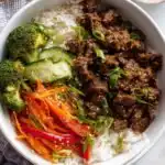 Teriyaki Beef Bowls 18 Overhead view of a high protein teriyaki beef bowl with seasoned ground beef, broccoli, bell peppers, carrots, and cauliflower jasmine rice blend topped with green onions